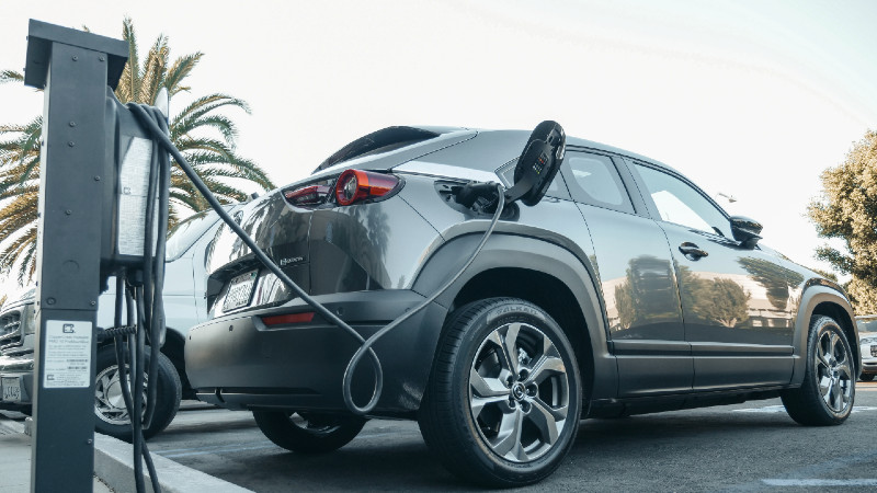 Grey electric vehicle parked and charging