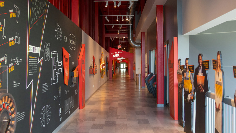 A bright alley with photos and museum exhibits lines the wall