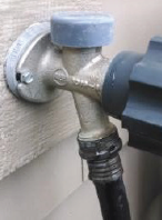 Grey outdoor hose spigot with a built in vacuum breaker