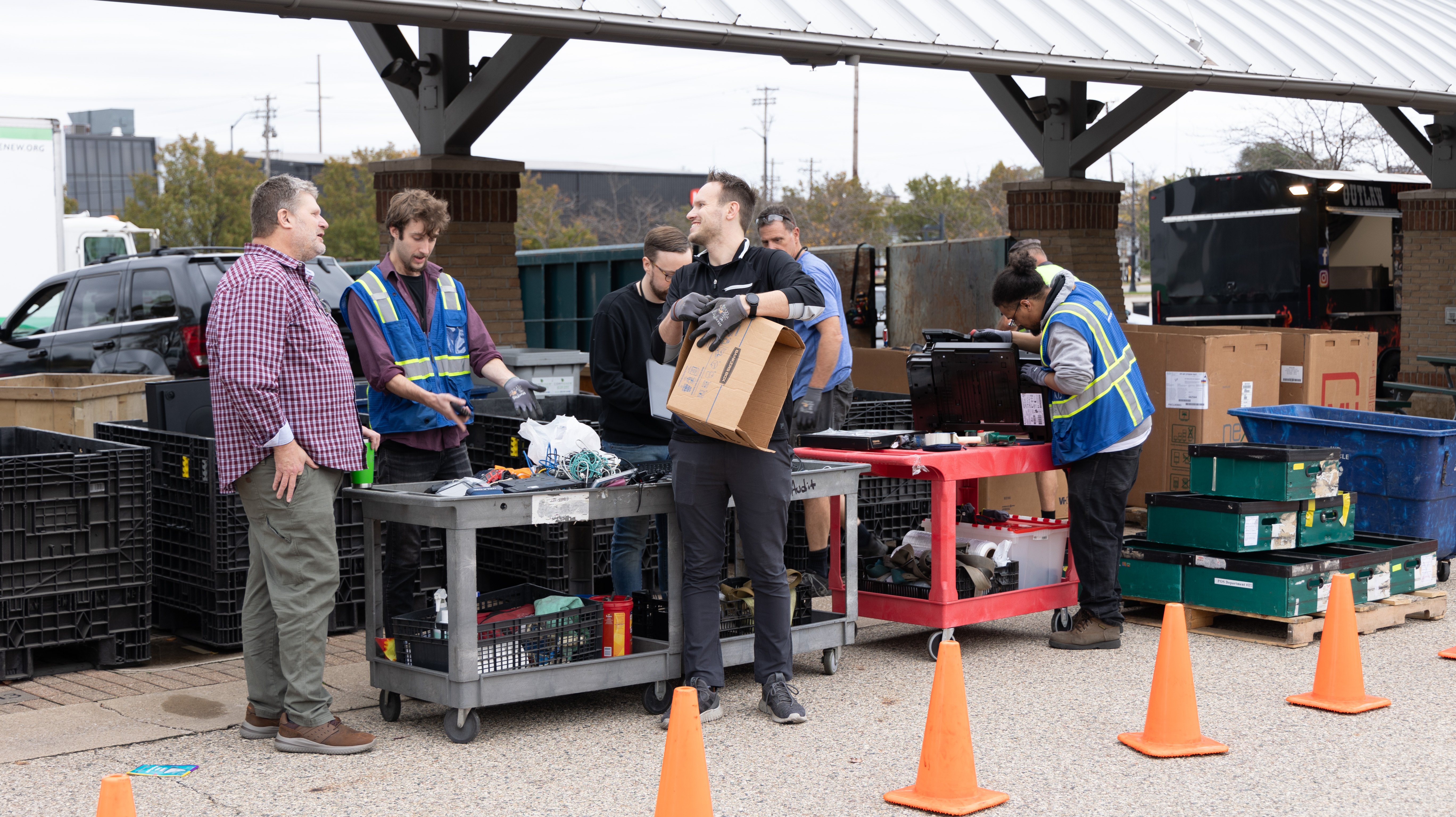 Men loading electronics into plastic bins