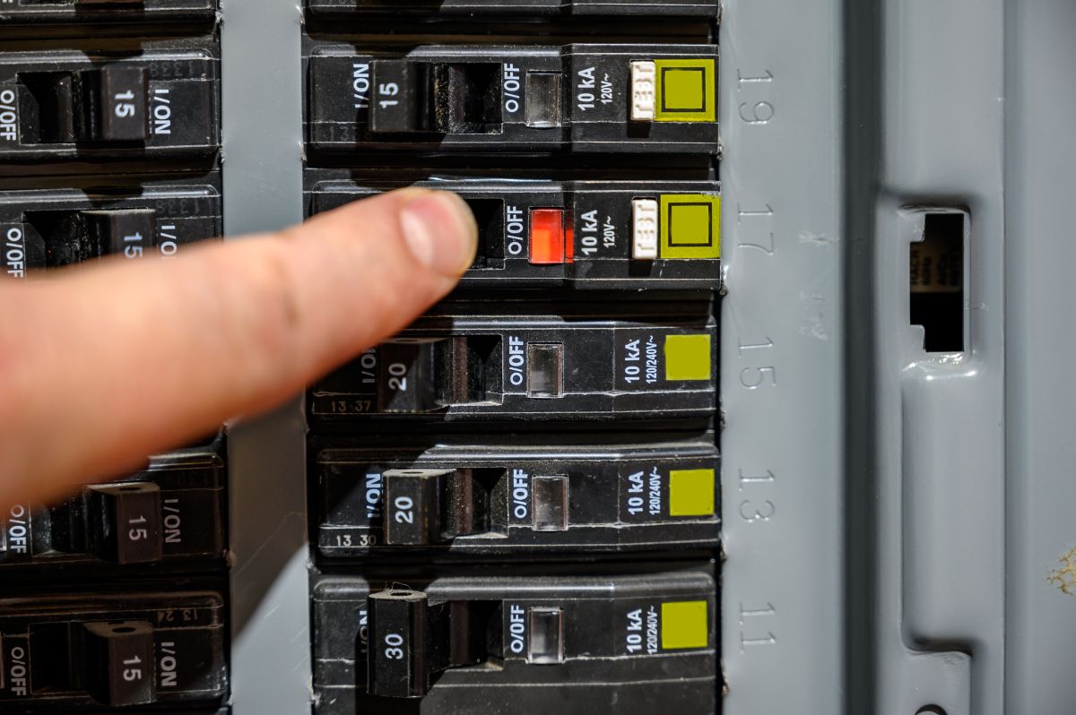 person resetting a tripped breaker