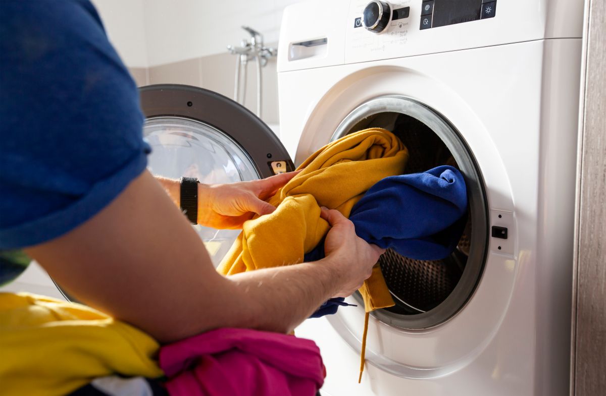person loading a clothes washer