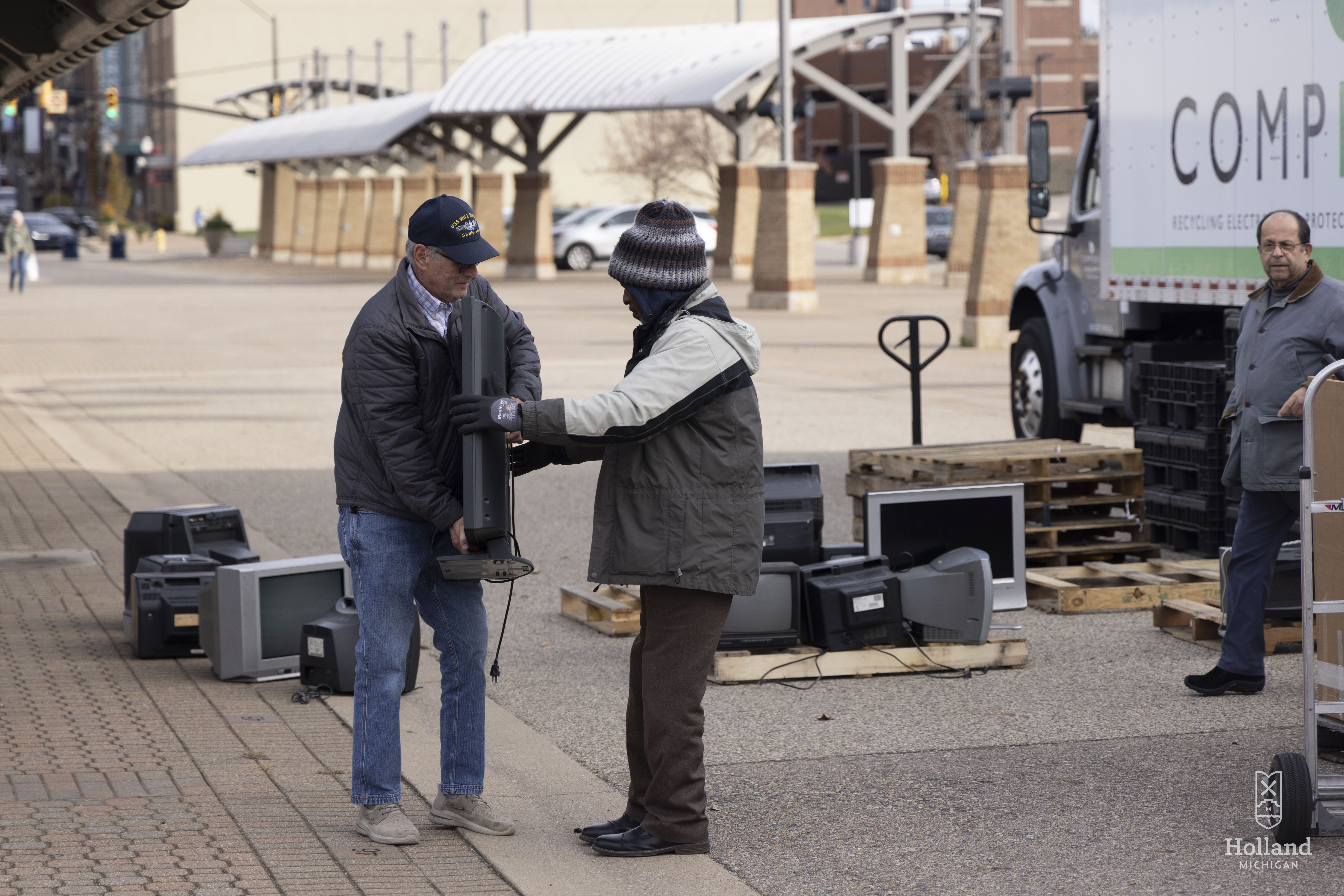 Men loading electronics into plastic bins