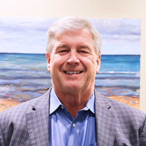 male executive wearing a checkered grey suitcoat over a blue shirt