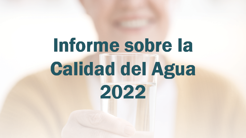 Woman holds water glass with &quot;Informe sobre la Calidad del Agua 2022&quot;